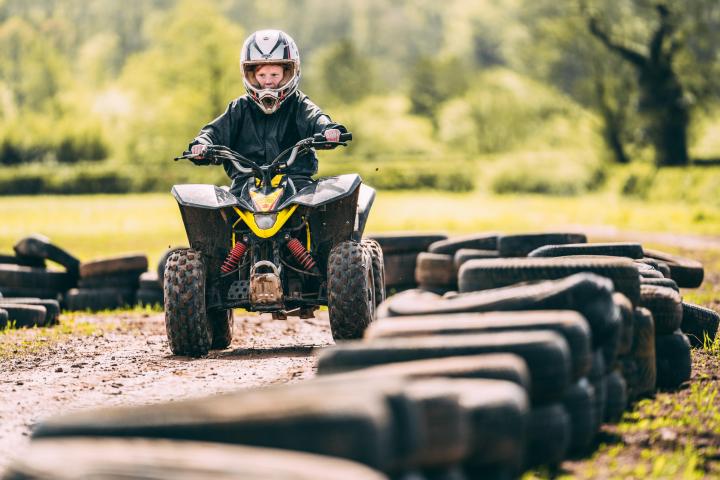 a man riding a motorcycle down a dirt road