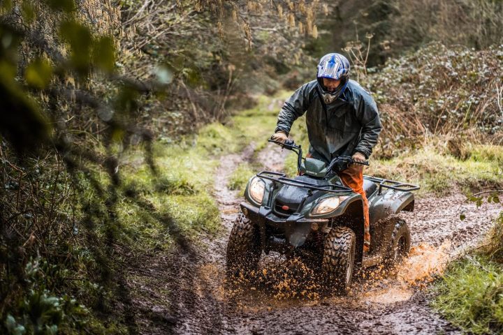 a man riding a motorcycle down a dirt road