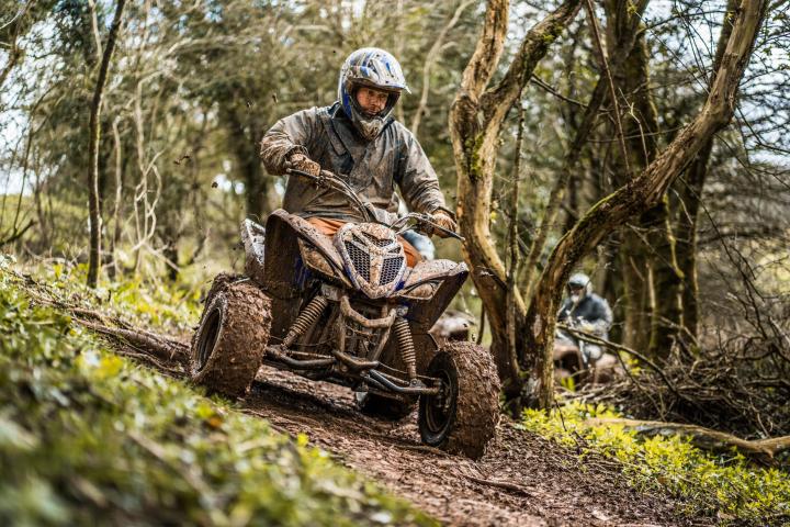 a man riding a motorcycle down a dirt road